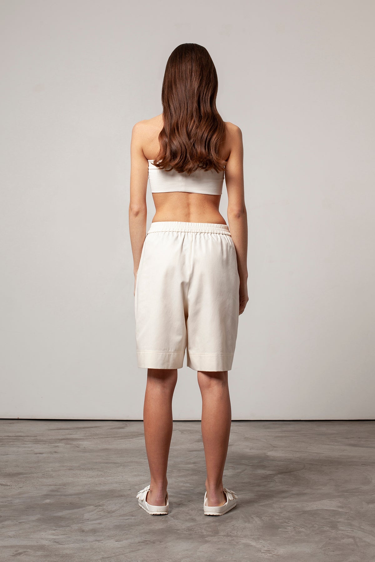 Léa is wearing White Canvas sustainable natural beige color, organic cotton, genderless, inclusive, casual short, size S styled with a natural jersey crop top. The Essential short has minimal modern aesthetics design allowing comfort and bringing self-confidence. A limited-edition production is made locally in France to reduce environmental impact and guarantee high quality and durability of the products.