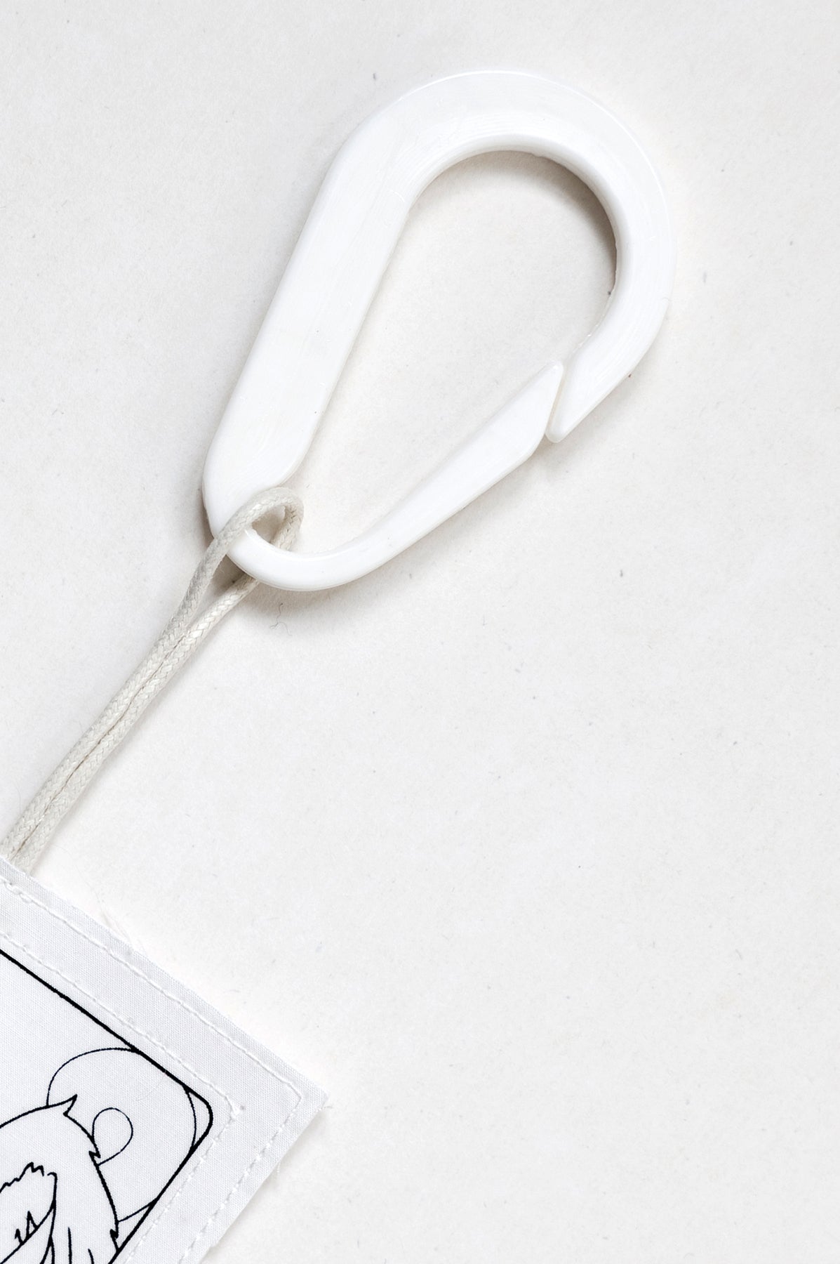 THE TWO OF CUPS tag is made from leftover deadstock white cotton poplin. The black and white tag has an exclusive design inspired by tarot cards drawn by the artist Maria Robla and is printed in collaboration with RoStudio. Wear the tag alone or attach it to the essential pieces to personalize them. The tag is sold with key holder in recycled plastic made in collaboration with Samji Atelier. White Canvas x Maria Robla.