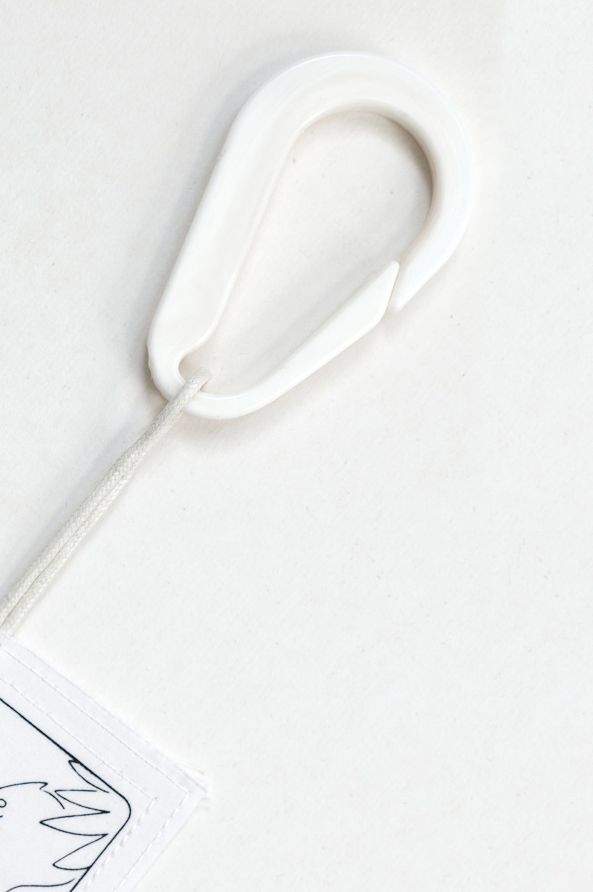 THE WORLD tag is made from leftover deadstock white cotton poplin. The black and white tag has an exclusive design inspired by tarot cards drawn by the artist Maria Robla and is printed in collaboration with RoStudio. Wear the tag alone or attach it to the essential pieces to personalize them. The tag is sold with key holder in recycled plastic made in collaboration with Samji Atelier. White Canvas x Maria Robla.