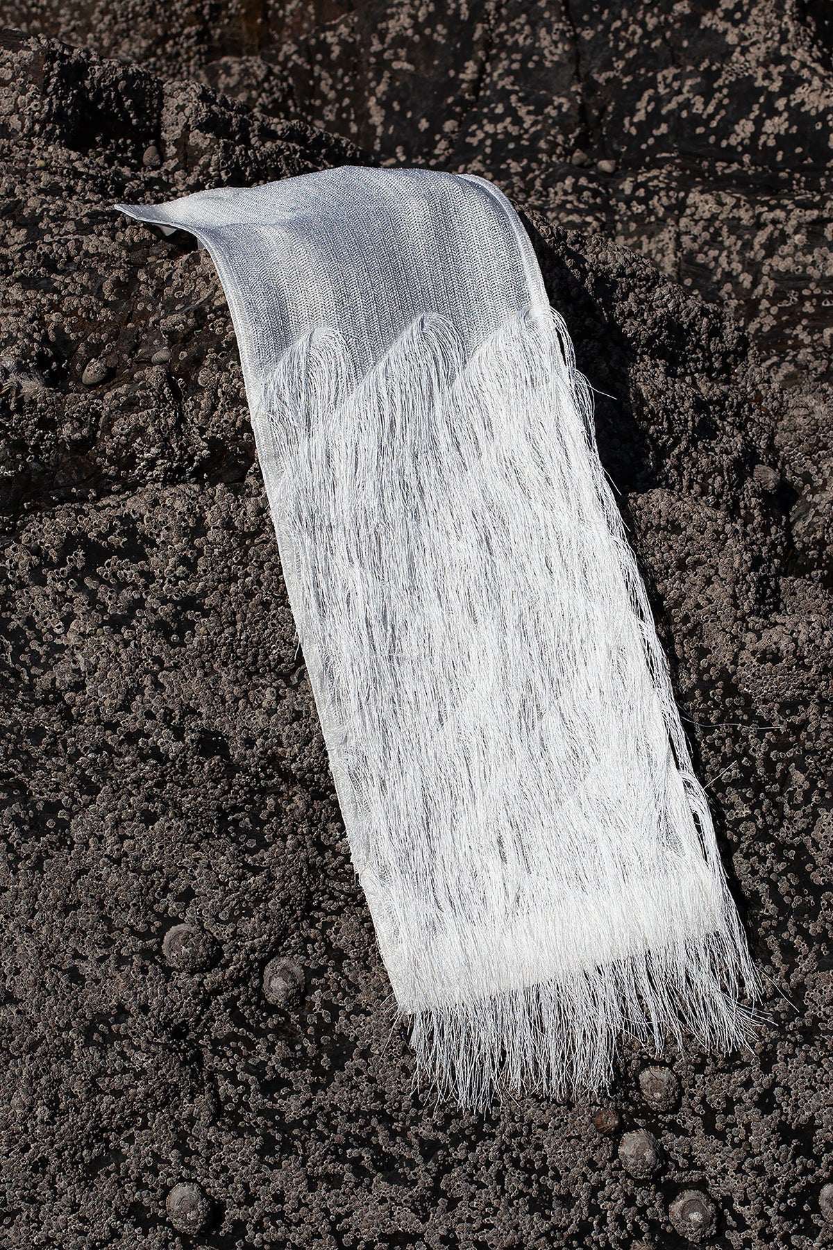 The silver fringes panel is an exclusive unique sustainable piece made in France. It is made to be attached to the essential pieces to personalize them and wear them your unique way.