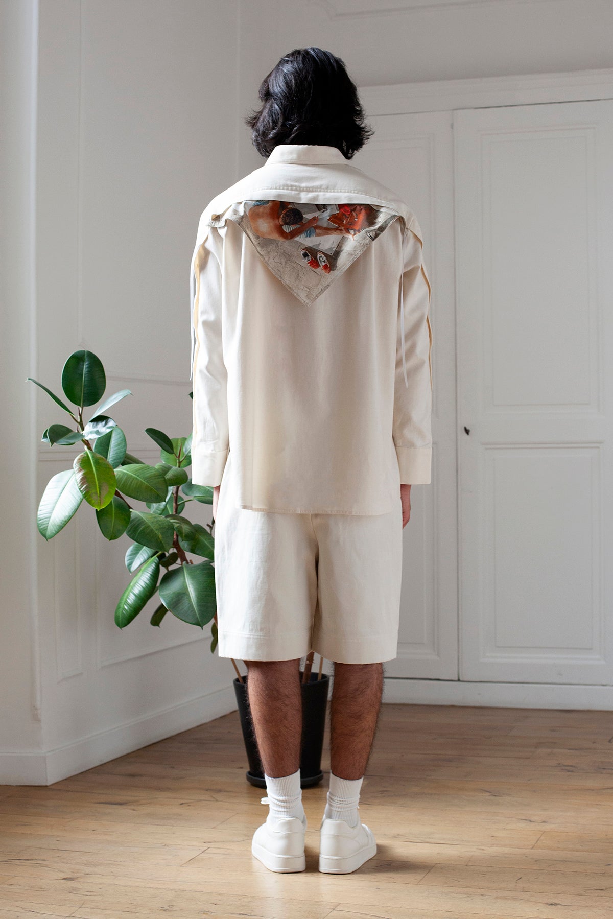 Medhi is wearing the White Canvas essential shirt styled with the Neswpaper triangular panel and bandana made from deadstock cotton poplin. The bandana has an exclusive print of a photo by the photographer Henrique Soares. Attach the panel to the essential pieces to personalize them and wear them your unique way. It is the perfect creative summer accessory.