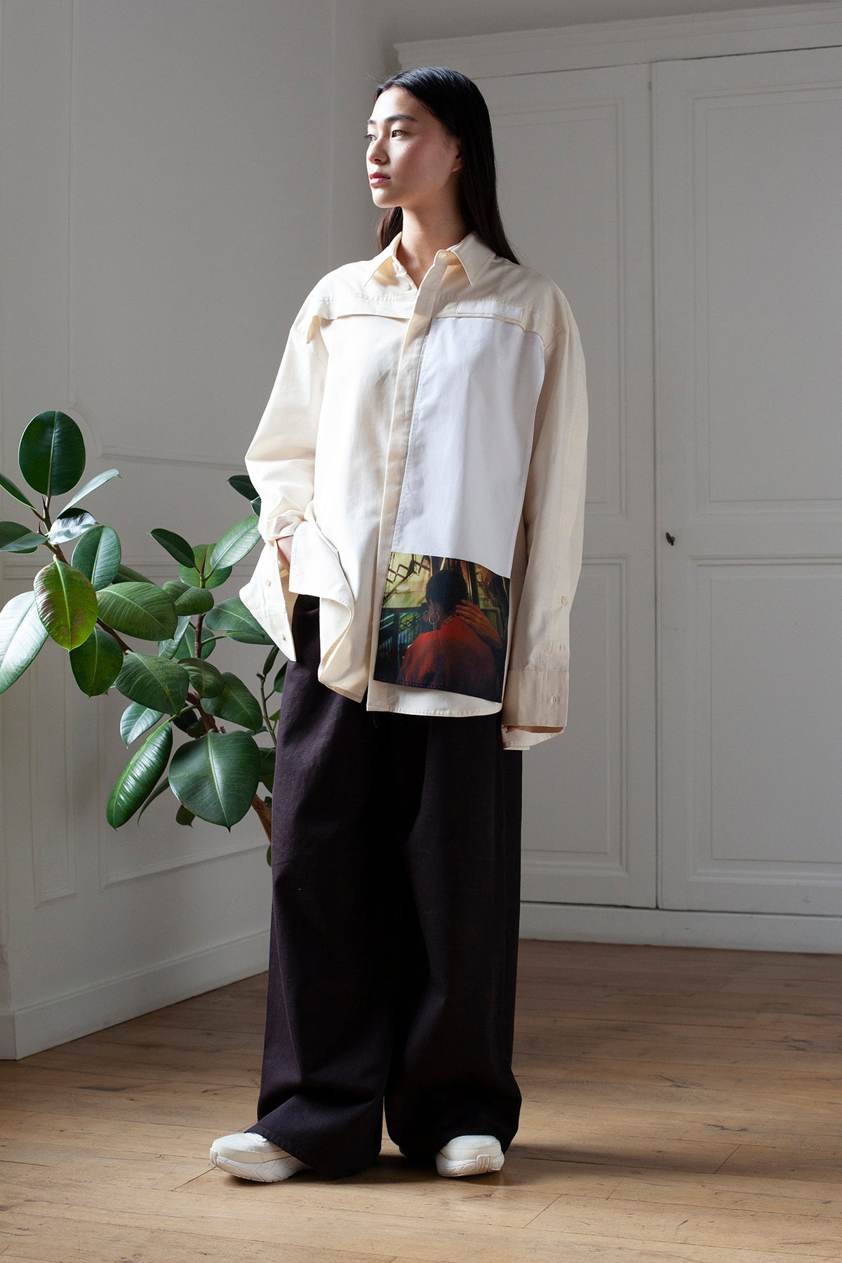SiJia is wearing the White Canvas cotton t-shirt styled with the Hand vertical panel made from deadstock cotton poplin. The panel has an exclusive print of a photo by the photographer Henrique Soares. Attach the panel to the essential pieces to personalize them and wear them your unique way. It is the perfect creative summer accessory.