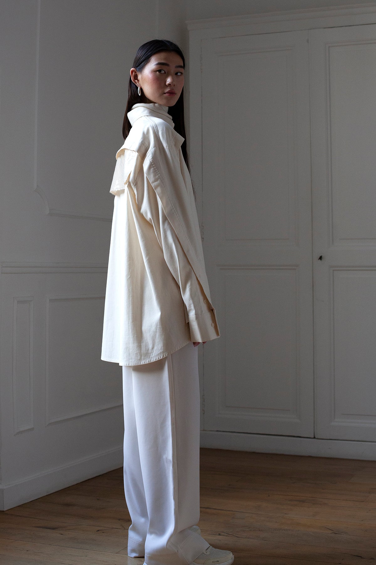 SiJia is wearing the White Canvas ESSENTIAL SHIRT styled at the back with the sequins horizontal panel made from deadstock fabrics. The sequins horizontal panel is an exclusive unique sustainable piece made in France. It is made to be attached to the essential pieces to personalize them and wear them your unique way.
