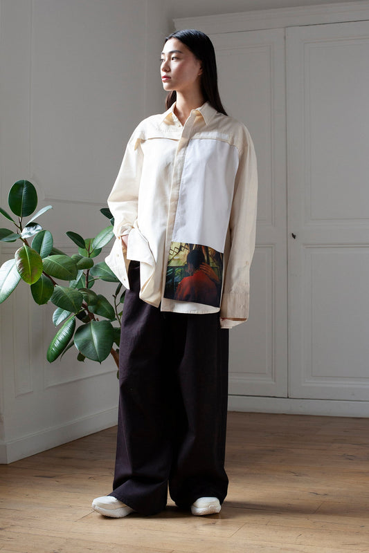 SiJia is wearing the White Canvas cotton t-shirt styled with the Hand vertical panel made from deadstock cotton poplin. The panel has an exclusive print of a photo by the photographer Henrique Soares. Attach the panel to the essential pieces to personalize them and wear them your unique way. It is the perfect creative summer accessory.